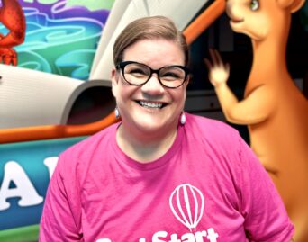 lady wearing glasses and a pink shirt with the Best Start Logo on it